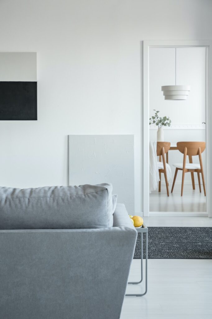 Trendy Open Space Living And Dining Room Interior With Grey Couch And Wooden Furniture 682x1024